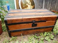 Front view showing wood panels, metal straps, central latch