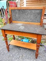 Front view showing pine frame, turned legs, slate top and backsplash