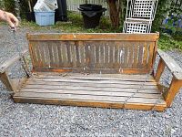 Front view of wooden porch swing with attached metal chains