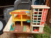 Overall view of the vintage Fisher Price Parking Ramp Service Center playset showing the parking levels, red lever, gas pump, and elevator tower.