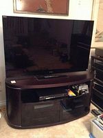 Front view of TV on stand with media components visible