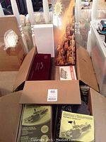 Boxed lot overview showing packaging for fishing kits, abacus case, chess set box, puzzle poster and other boxes
