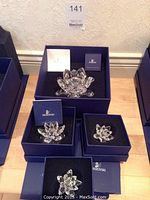 All four Waterlily candleholders in original boxes with certificates and packaging visible
