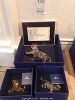 Adult tiger figurine in blue presentation box with signed card displayed behind