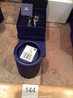 Two deep blue presentation boxes open showing certificate booklet and figurine inside