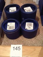 Four round blue Swarovski packaging boxes with model number labels on lids