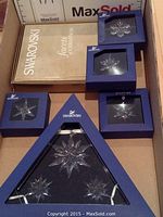 All six items laid out in box: triangular set, four square boxes, gold certificate folder