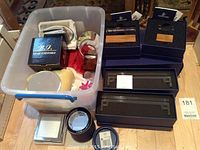 Wide view of all items including plastic bin with assorted display parts, boxes of Swarovski crystal stands, and B.J. light turntable box.