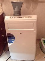 Front view of white portable air conditioner with exhaust hose attached to top vent