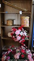 Photo of wooden bookcase shelves showing artificial flowers and woven baskets