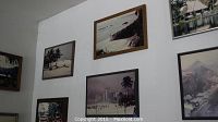 Wall display with multiple framed vintage photographs, mostly scenic nature and cityscape images