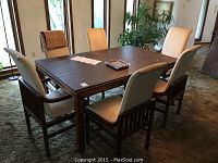 Full view of rectangular wood dining table with six upholstered chairs surrounding