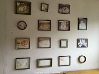 Wall with 15 sepia-toned framed photographs mostly of dogs, various sizes, some frames empty or damaged.