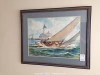Framed signed print of sailing ship on ocean with lighthouse in background