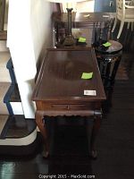 Front view of Ethan Allen wooden low table showing top surface, cabriole legs and a slide out shelf on one side.