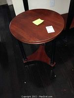 Photo of low round wooden side table from top angle displaying wood grain and round surface.