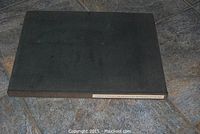 Closed view of black hardcover book on tile floor