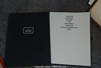 Black cloth-bound portfolio open showing title page 'Twelve Instant Images on Polaroid TPE-105 Positive/Negative Film'