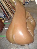 Side-angle view of bronze sculpture showing smooth, flowing shapes and patina.