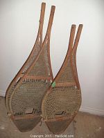 Pair of snowshoes leaning against wall on bare floor