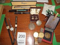 Overview of lot showing pens, watches, cufflinks, medallions