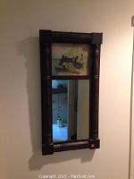 Full view of the rectangular wall mirror with wooden frame and duck illustration panel at the top.