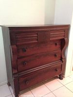 Front view of chest showing 3 top smaller drawers with carved panels and 3 large bottom drawers with rounded molding and wooden knobs.