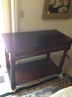 Front view of the wooden side server table showing the two drawers and lower shelf with carved legs.