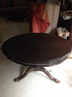 Top view of the dark wood oval table showing scalloped edge and smooth surface.