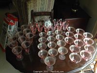 Photo showing the full set of cranberry bubble glassware with water glasses, parfait cups, dessert cups, and dessert bowls arranged on a table surface
