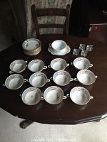 Top view of twelve cream soup bowls with floral and gold detail.