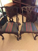 Overall front view of both chairs showing carved backs and striped upholstery