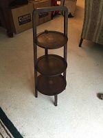 Front view of the 3 tiered wooden tray end table showing the three circular trays and vertical handle.