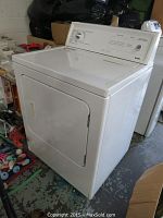Angled front view of white Kenmore dryer showing door, cabinet and part of control console
