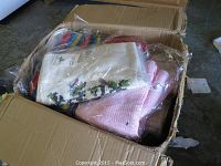 Box showing assorted packaged children's sweaters in various colors and patterns.