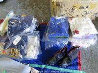 Overview of assorted packaged children's sweaters and size 9 cowboy boots arranged on a floor mat.