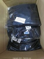 Three navy blue men's sweaters in sealed plastic packaging inside a cardboard box.