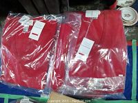 Multiple packaged red wool sweaters, showing new condition and packaging.