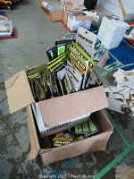 Box containing multiple packages of Snap-N-Go safety reflector bracelets with visible neon green bracelets inside.