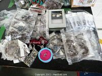Photo of assorted costume jewellery on a table including multiple bracelets, necklace sets, and packaged jewellery pieces.