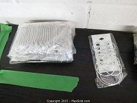 72 individually bagged silver-tone stretchy bracelets arranged flat on table.