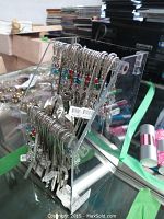 View of the clear acrylic stand holding multiple metal bookmarks with beaded decorations and snowflake charms.