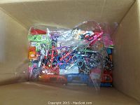 Top view image showing a box containing assorted scissors, magnifiers, and lighting devices.