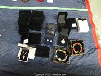 Photo showing overall assortment of jewelry including bracelets in boxes, heart-shaped earrings in box, silver pendant necklace, and multiple jewelry boxes