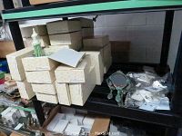 Stack of beige small jewellery holder boxes and small decorative mirrors with hanging tassels on lower shelf.