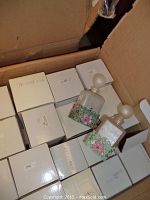 Photo of box with multiple boxed perfume bottles and two decorative perfume bottles on top.