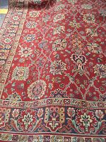 Full view of rug front showing red ground and floral pattern