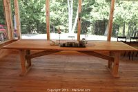 Front view of full-length cedar table on screened porch