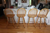 Four stools lined up at kitchen island showing backs and seats