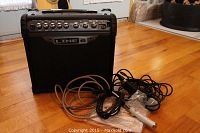 Front and top view of the Line 6 Spider III amplifier along with the microphone and cables placed on the floor, showing the control panel and branding.